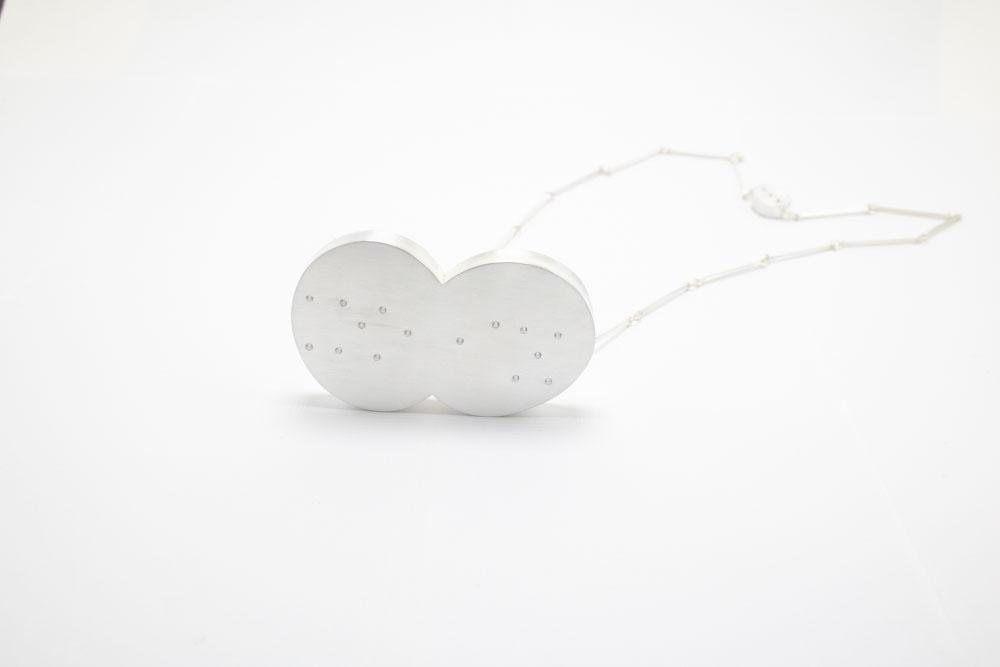 Silver necklace of two joined round forms set with small stones