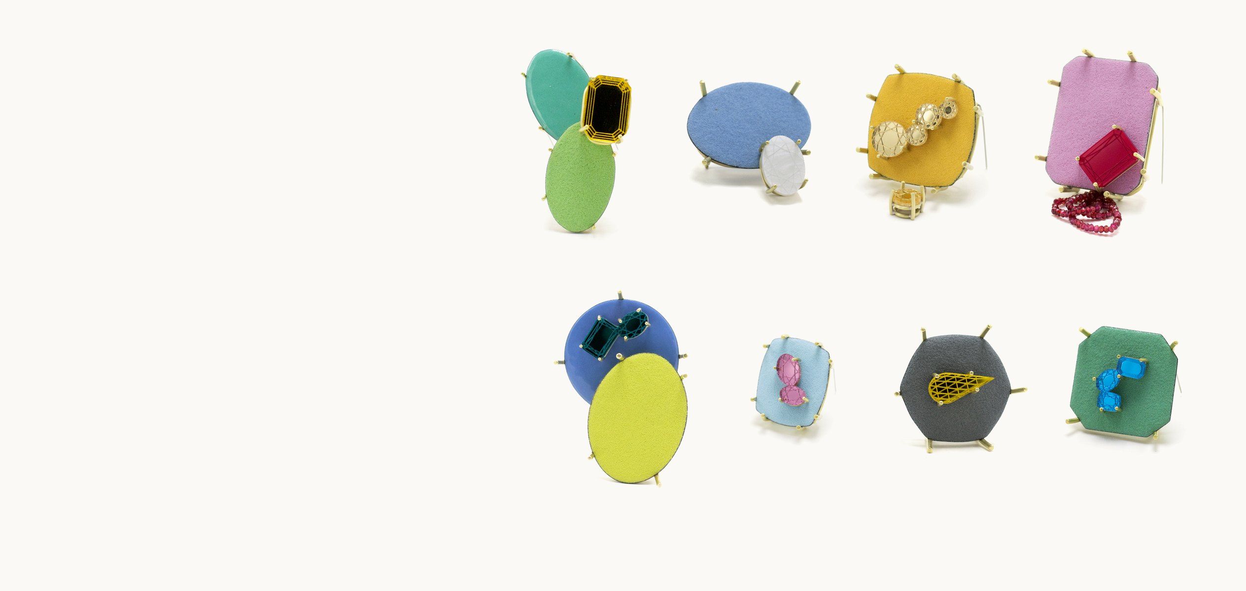 Eight enamel brooches from The quiet practice of becoming, in green, blue, yellow, pink and grey, set with faceted acrylic stones and held by brass prongs