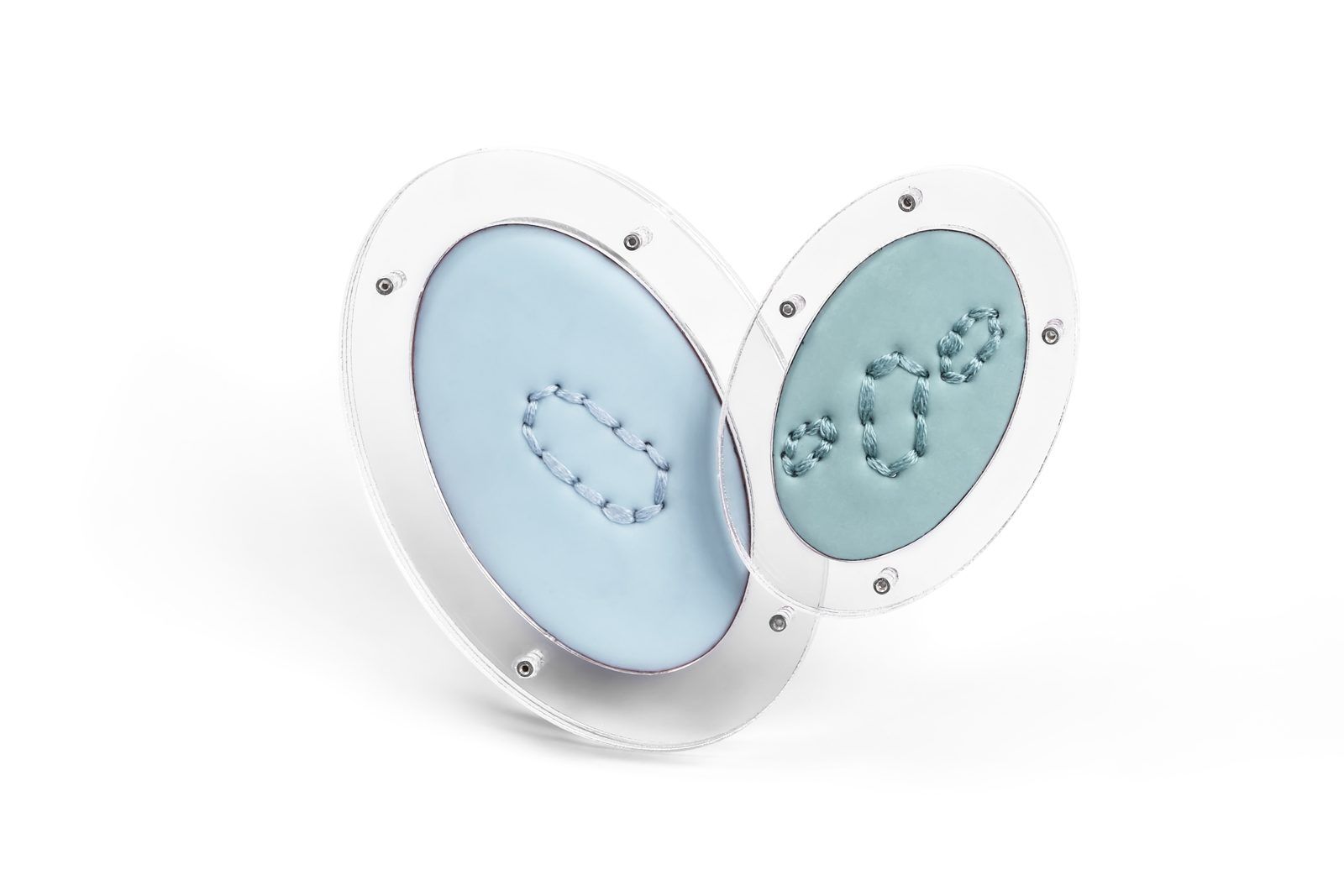 Two powder-blue enamel brooches set in clear acrylic