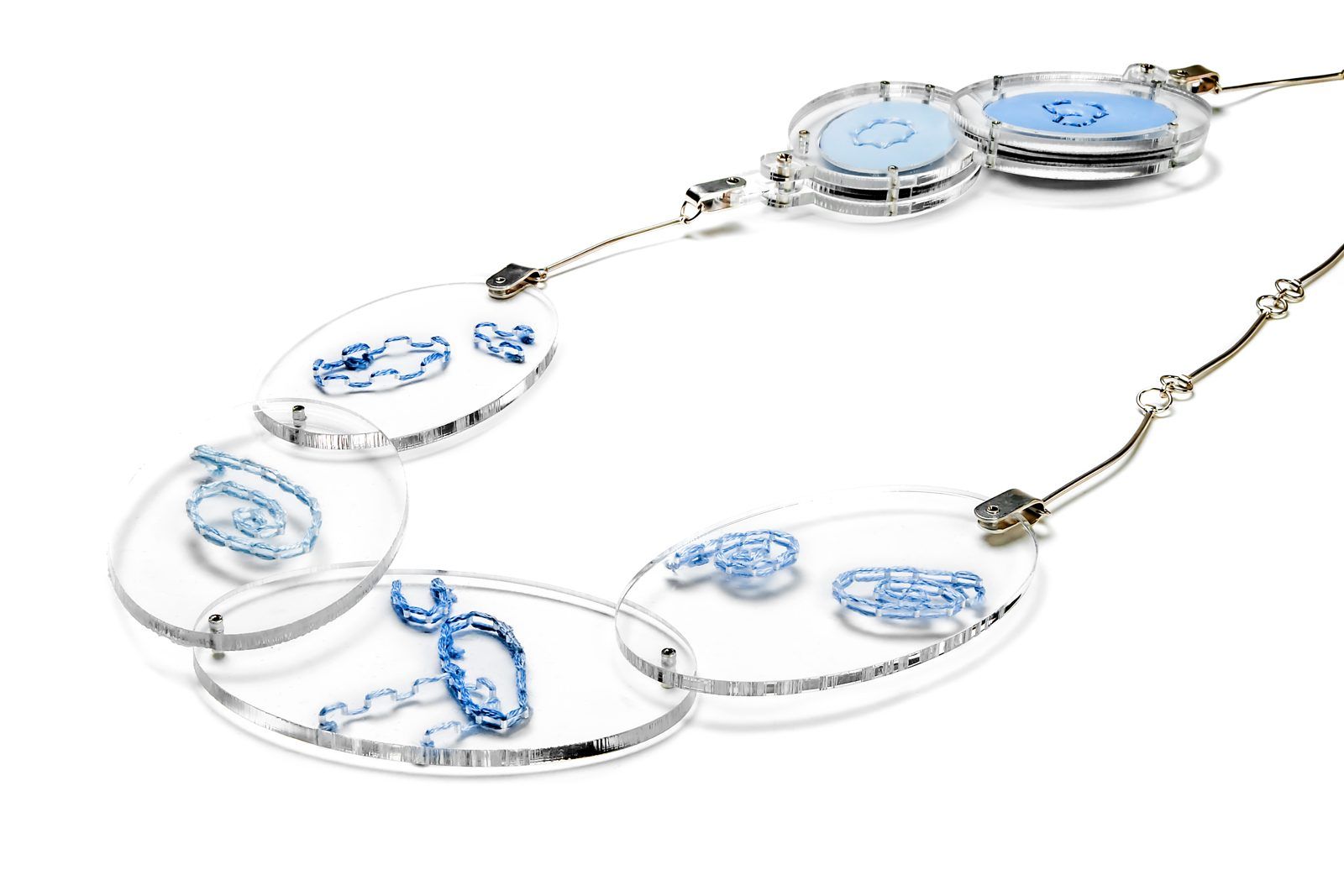 Long necklace of clear links with blue embroidered enamel