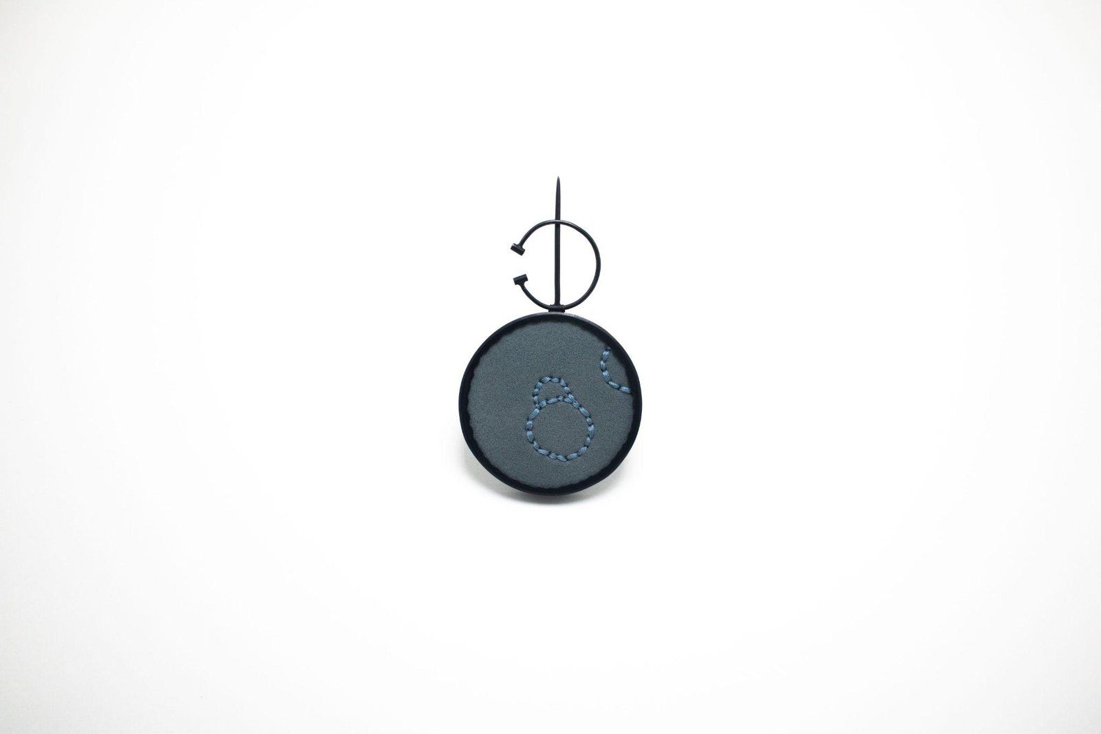 Round dark blue enamel brooch with embroidered stitching