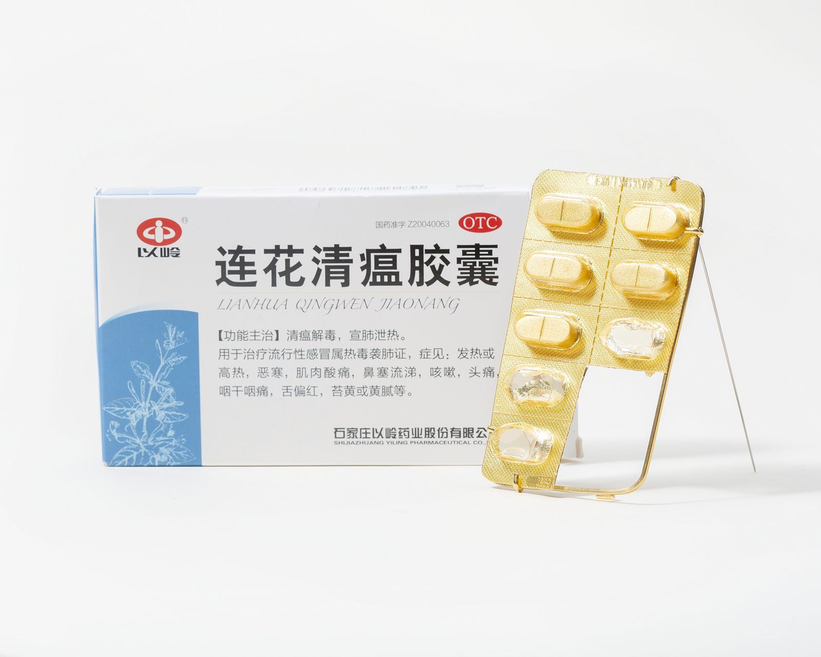 Gold blister-pack brooch beside a medicine box