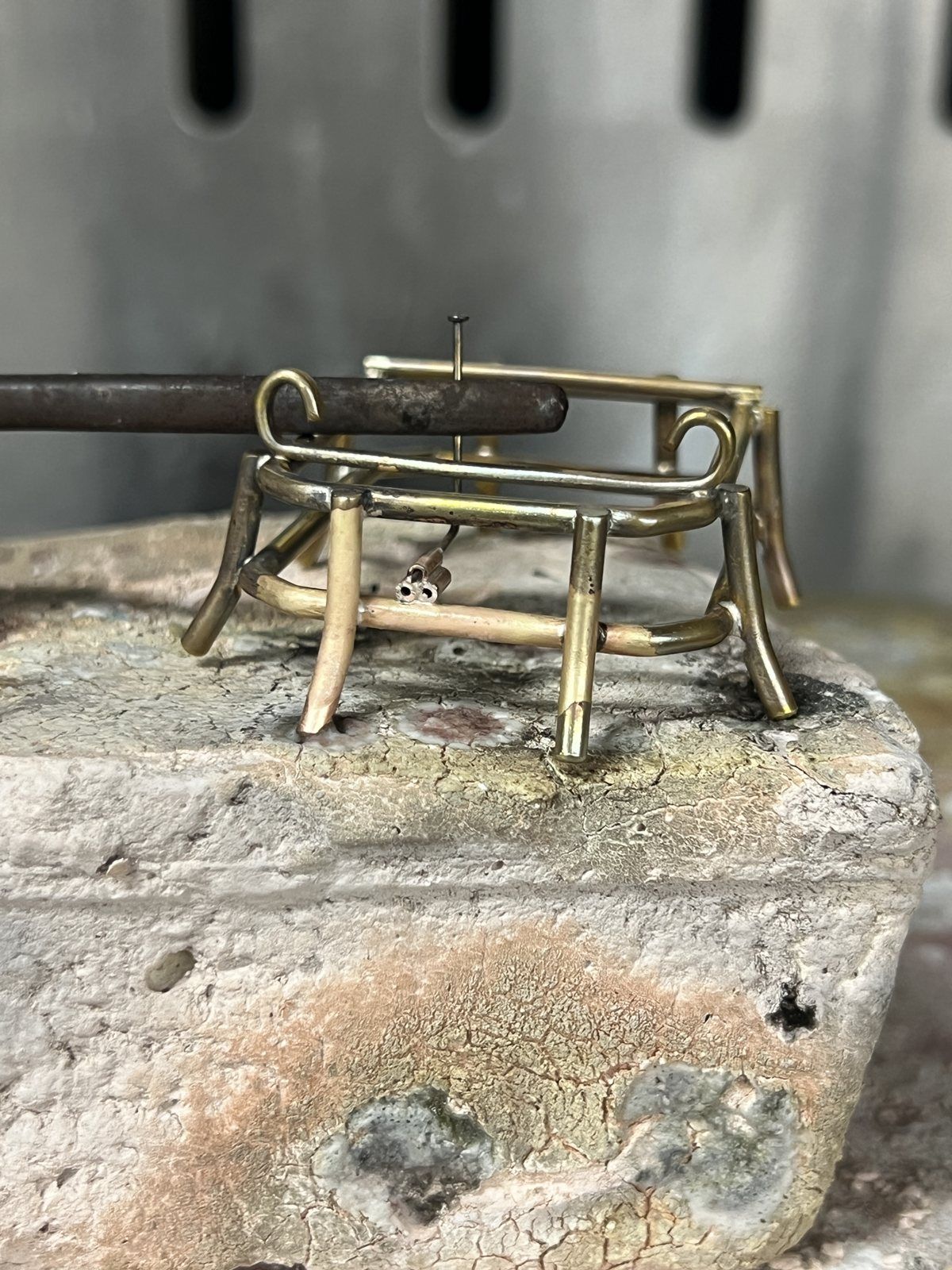 A brass frame being soldered on a soldering block
