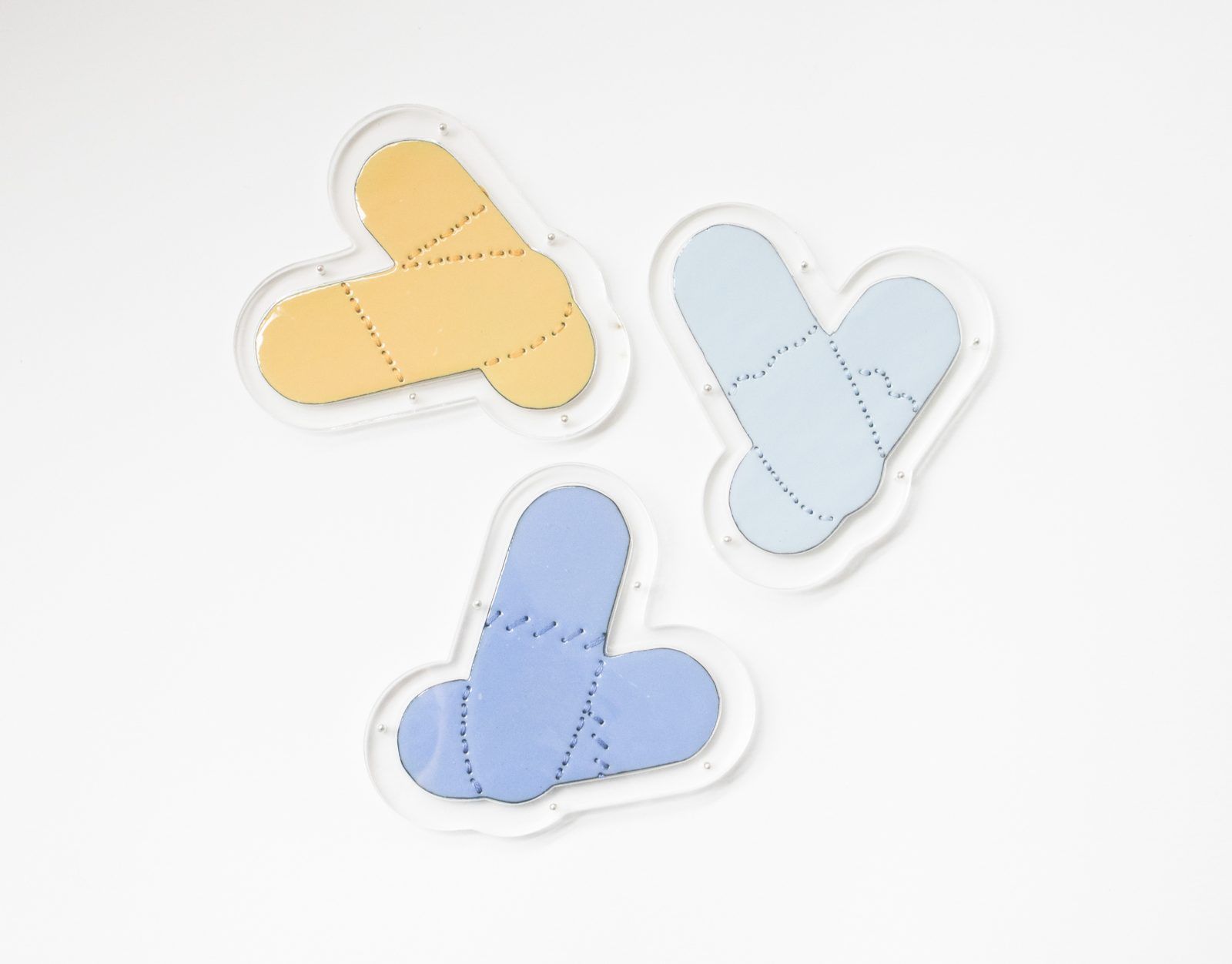 Peach and blue enamel pill forms in clear acrylic