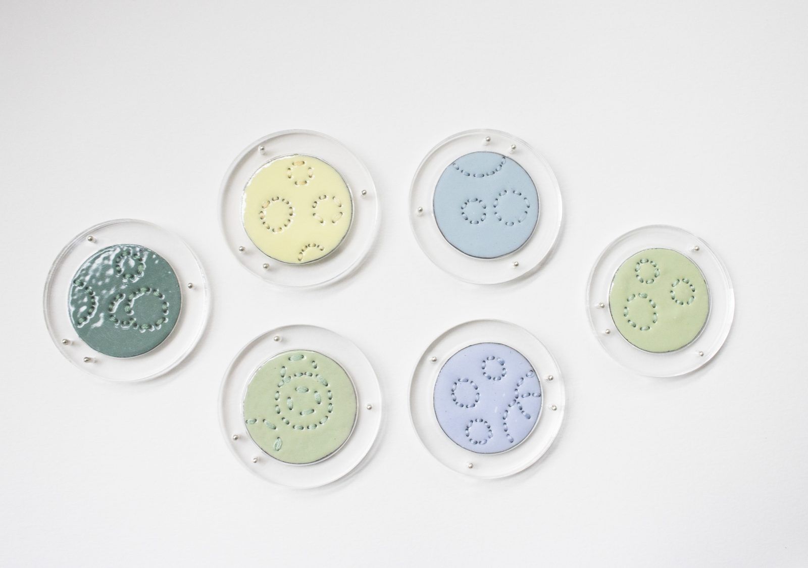 Round pastel enamel discs with stitched patterns